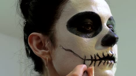 Woman-finishing-Day-of-the-Dead,Halloween-makeup