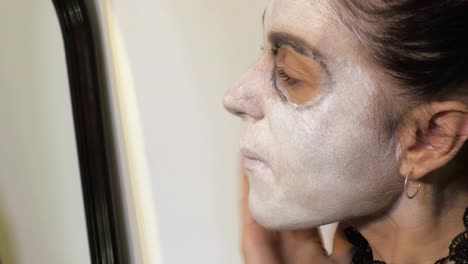 Frau-wenden-Halloween-Make-up-in-der-Nähe-von-Spiegel