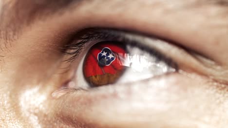 Hombre-con-el-ojo-marrón-de-cerca,-la-bandera-del-estado-de-Tennessee-en-iris,-estados-unidos-de-América-con-movimiento-de-viento.-concepto-de-vídeo