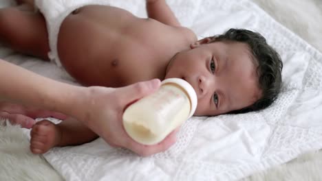 Mutter-füttert-Milch-an-Neugeborene-aus-einer-Flasche.