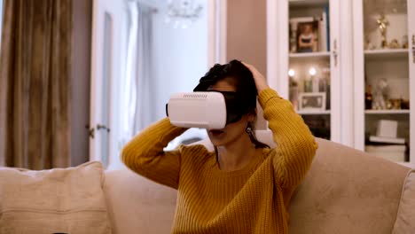 Junge-Frau-trägt-VR-Kopfhörer-zu-Hause,-schaut-sich-um-und-nehmen-Sie-die-Gläser-der-virtuellen-Realität