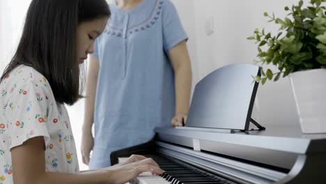 4K-:-Slow-motion-of-Asian-girl-playing-piano-with-her-mother