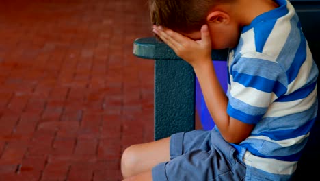 Sad-schoolboy-sitting-in-locker-room-4k