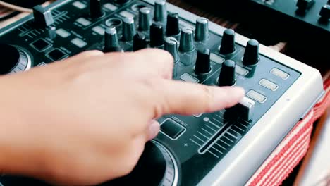 DJ-console-or-mixer,-the-hand-presses-the-levers-and-buttons-of-remote