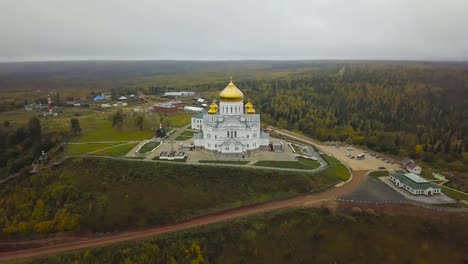 Aérea-vista-de-iglesia-y-emblemático,-cúpulas-doradas-amarillo-al-aire-libre-en-otoño.-Clip.-Vista-superior-de-la-iglesia-en-otoño