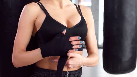 Athletic-nice-girl-wearing-sportswear-preparing-for-combat-at-sport-gym