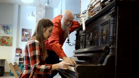 El-abuelo-escucha-nieta-juega-en-el-piano