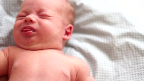 Close-up-portrait-of-a-crying-newborn-baby-in-bed.-A-two-week-old-baby-wakes-up-from-colic.-A-dream-of-a-newborn.-Children's-Day.-Protection-of-children