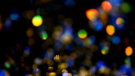 Defocused-shimmering-multicolored-glitter-confetti,-black-background.-Holiday-abstract-festive-bokeh-light-spots.