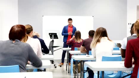 männliche-Schüler-am-Whiteboard-vor-Gruppen-von-Schülern-beantworten