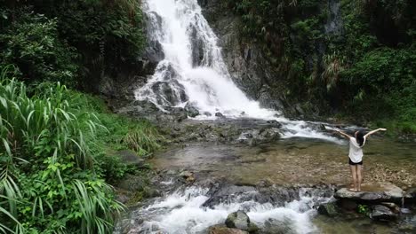 Healthy-lifestyle-woman-doing-yoga-near-waterfall-in-forest