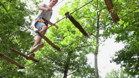 Child-passing-route-in-rope-park,-Safety-equipment-carabiner-and-ropes-for-climbing-trees-in-extreme-park