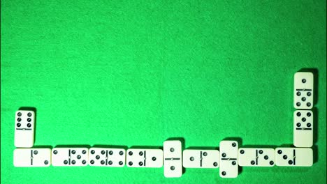 Stop-motion-of-domino-game-on-green-cloth-background.