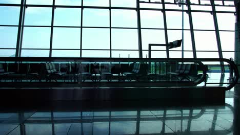 Silhouette-der-Passagiere-zu-Fuß-in-der-belebten-internationalen-terminal-Halle-am-Flughafen