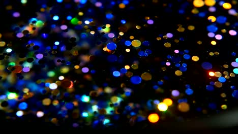 Defocused-shimmering-multicolored-glitter-confetti,-black-background.-Holiday-abstract-festive-bokeh-light-spots.