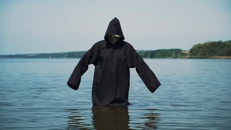 Scary-figure-in-black-mantle-in-the-river.