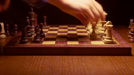 chess-player-making-a-move-in-the-game-on-wooden-table