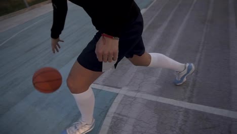 Female-basketball-player-in-morning-light-on-professional-court-running-with-ball.-Handhelded-footage