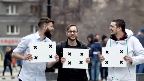 Cheerful-boys-talk-in-the-city-at-rally-and-smile.-Place-your-text-on-the-banner