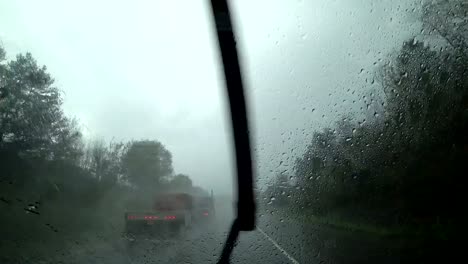 El-coche-está-conduciendo-en-lluvia-pesada-en-la-carretera