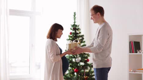 husband-giving-christmas-present-to-pregnant-wife