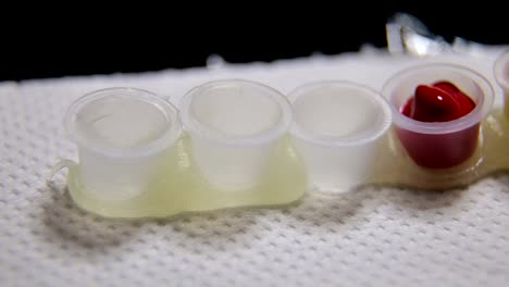 Close-up-of-the-tattoo-artist-prepares-containers-for-mixing-ink-for-the-tattoo.