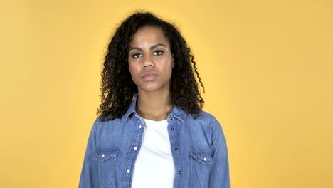 African-Girl-Gesturing-Thumbs-Down-Isolated-on-Yellow-Background