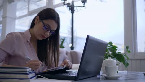 rageful-Studentin-zieht-aggressiv-und-werfen-zerknittertes-Papier-aus-Notebook-während-Fernstudium-mit-Laptop-aus-Online-Unterricht-lernen