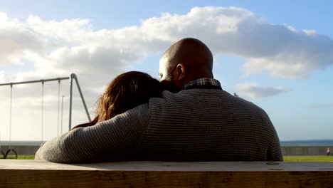 Rear-view-of-couple-sitting-on-bench-in-the-park-4k