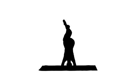 Silhouette-Beautiful-young-woman-doing-yoga-exercise-variation-of-supported-headstand,-garuda-salamba-sirsasana-with-crossed-legs