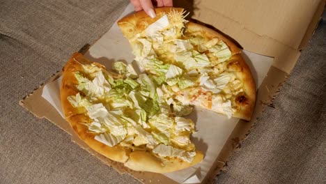 Ein-Stück-Pizza-in-der-hand