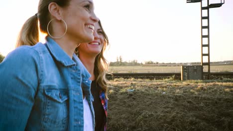 dos-mujeres-hermosas-y-jóvenes-caminando-y-hablando-con-patín