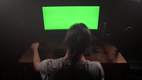 Pantalla-verde.-Un-hombre-mira-el-monitor-y-luego-pone-los-auriculares.-4K-Slow-mo