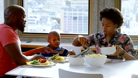 Familie-mit-Essen-am-Esstisch-in-einem-komfortablen-Haus-4k