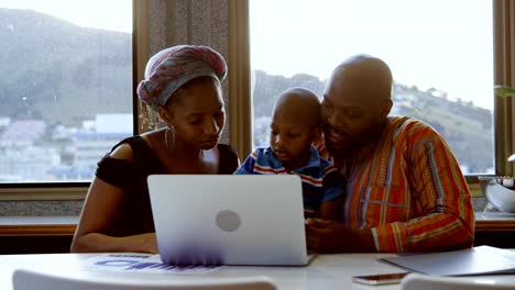 Parents-and-son-using-laptop-and-digital-tablet-at-home-4k