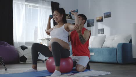 Young-man-instructing-pregnant-woman-during-workout