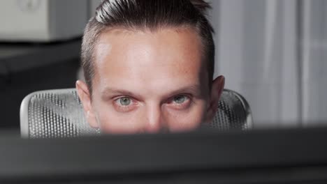 Sliding-cropped-shot-of-a-male-eyes-looking-at-computer-monitor