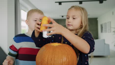 Vista-de-mano-de-calabaza-perforada-y-niños-curiosos