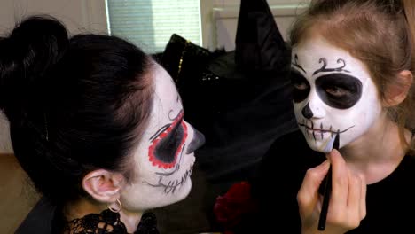 Frau-wenden-Halloween-Make-up-für-ihre-Tochter