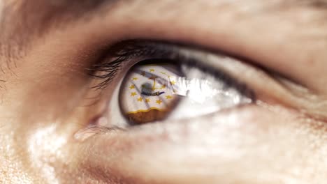 Man-with-brown-eye-in-close-up,-the-flag-of-Rhode-Island-state-in-iris,-united-states-of-america-with-wind-motion.-video-concept