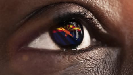 Woman-black-eye-in-close-up-with-the-flag-of-Arizona-state-in-iris,-united-states-of-america-with-wind-motion.-video-concept