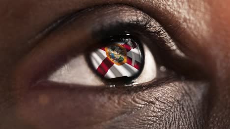 Mujer-ojo-negro-en-primer-plano-con-la-bandera-del-estado-de-Florida-en-iris,-estados-unidos-de-América-con-movimiento-de-viento.-concepto-de-vídeo