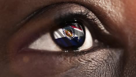 Woman-black-eye-in-close-up-with-the-flag-of-Missouri-state-in-iris,-united-states-of-america-with-wind-motion.-video-concept