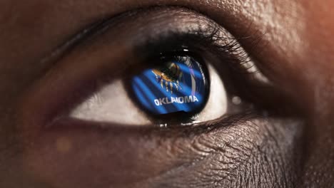 Woman-black-eye-in-close-up-with-the-flag-of-Oklahoma-state-in-iris,-united-states-of-america-with-wind-motion.-video-concept