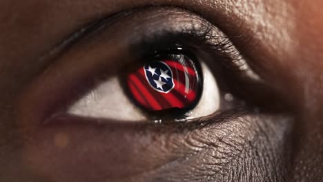 Woman-black-eye-in-close-up-with-the-flag-of-Tennessee-state-in-iris,-united-states-of-america-with-wind-motion.-video-concept