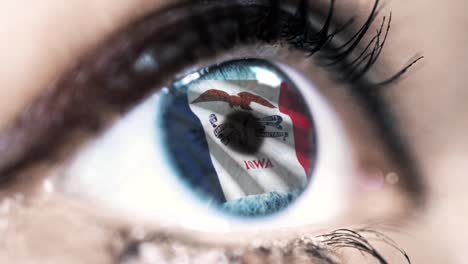 Mujer-ojo-azul-en-primer-plano-con-la-bandera-del-estado-de-Iowa-en-iris,-estados-unidos-de-América-con-movimiento-de-viento.-concepto-de-vídeo