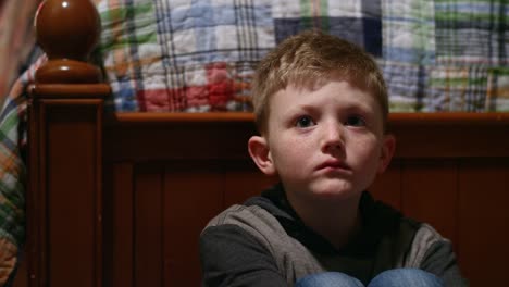 Sad-young-boy-sitting-in-his-room-alone