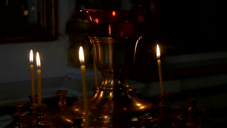 Burning-candles-in-front-of-the-altar-in-the-church.-Praying-parishioner-of-the-church.