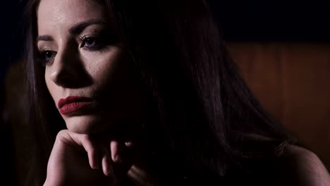 Close-up-on-sad,-pensive,-charming-woman-in-the-darkness