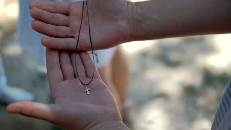 En-las-manos-humanas-se-encuentra-una-cruz-de-oro-poco-ortodoxa-en-una-cadena